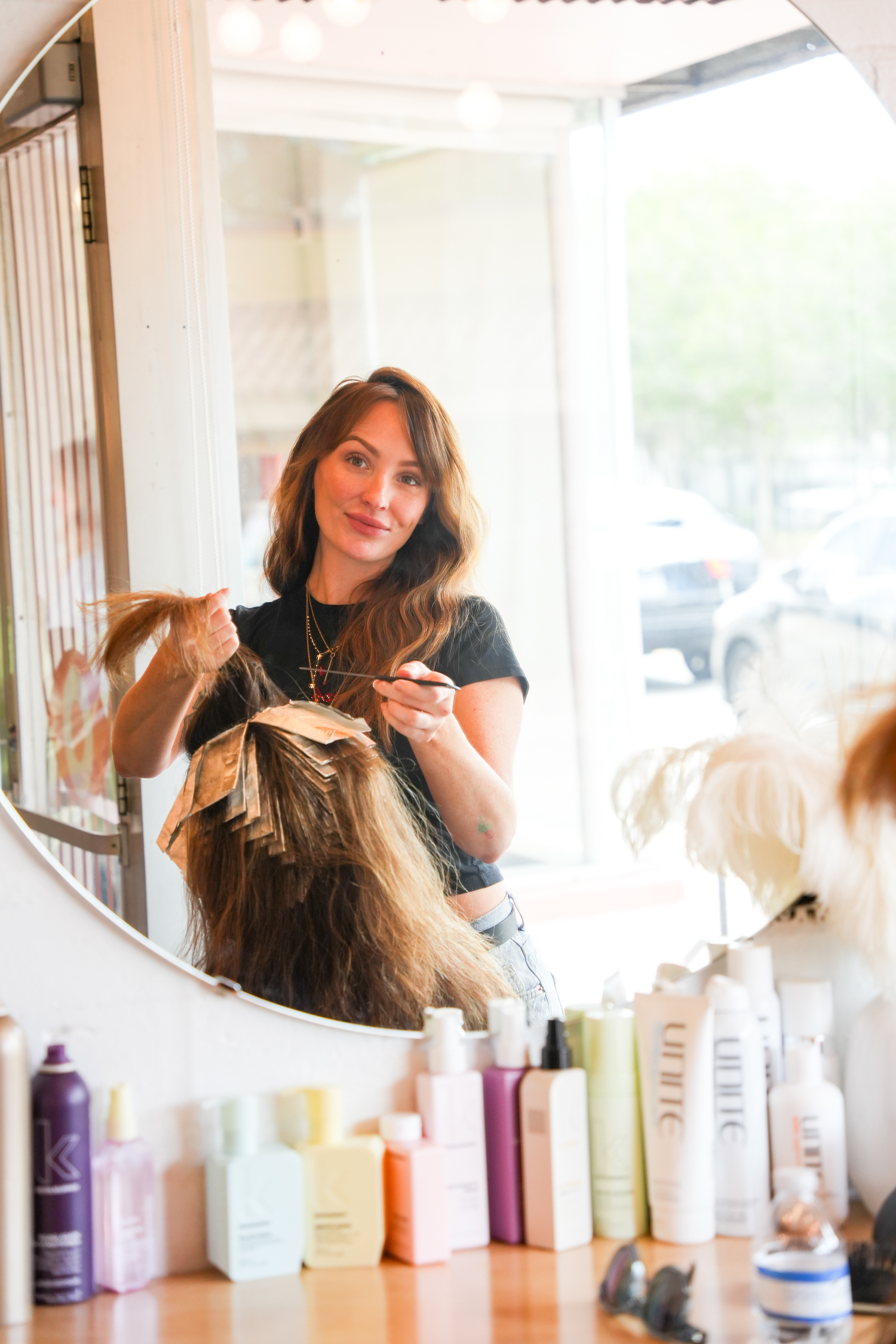 Jenna Bessi, stylist at Do or Dye, working on color at her station